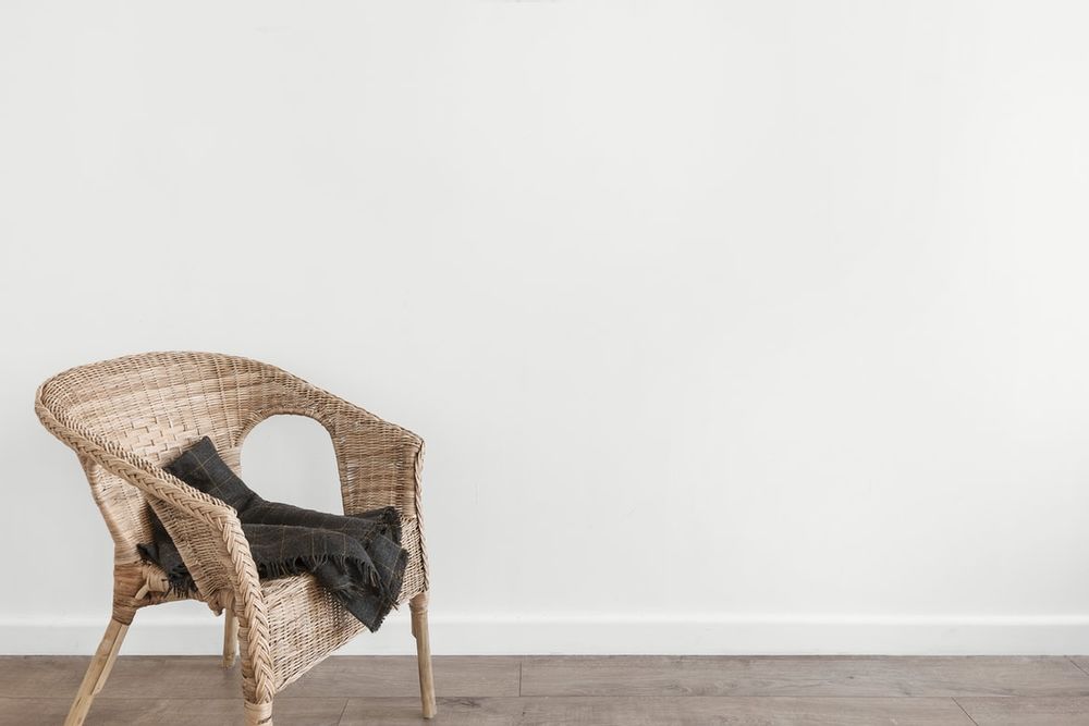 Lege wand met rieten stoel 